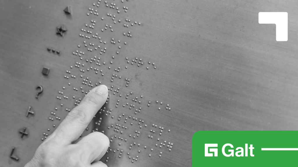 Hand reading Braille dots on a metal surface, symbolizing accessible communication.